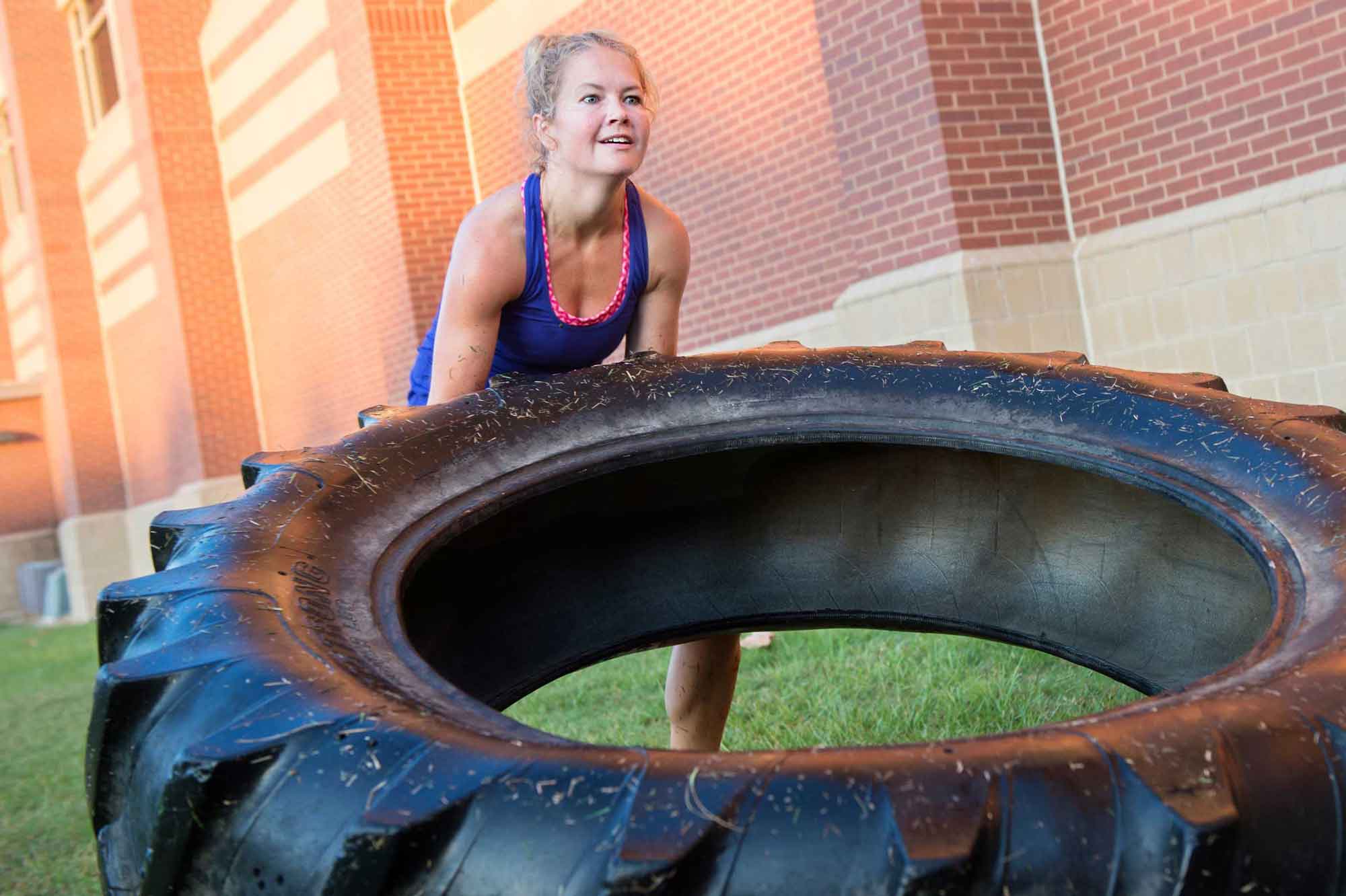 Woman moving large tire