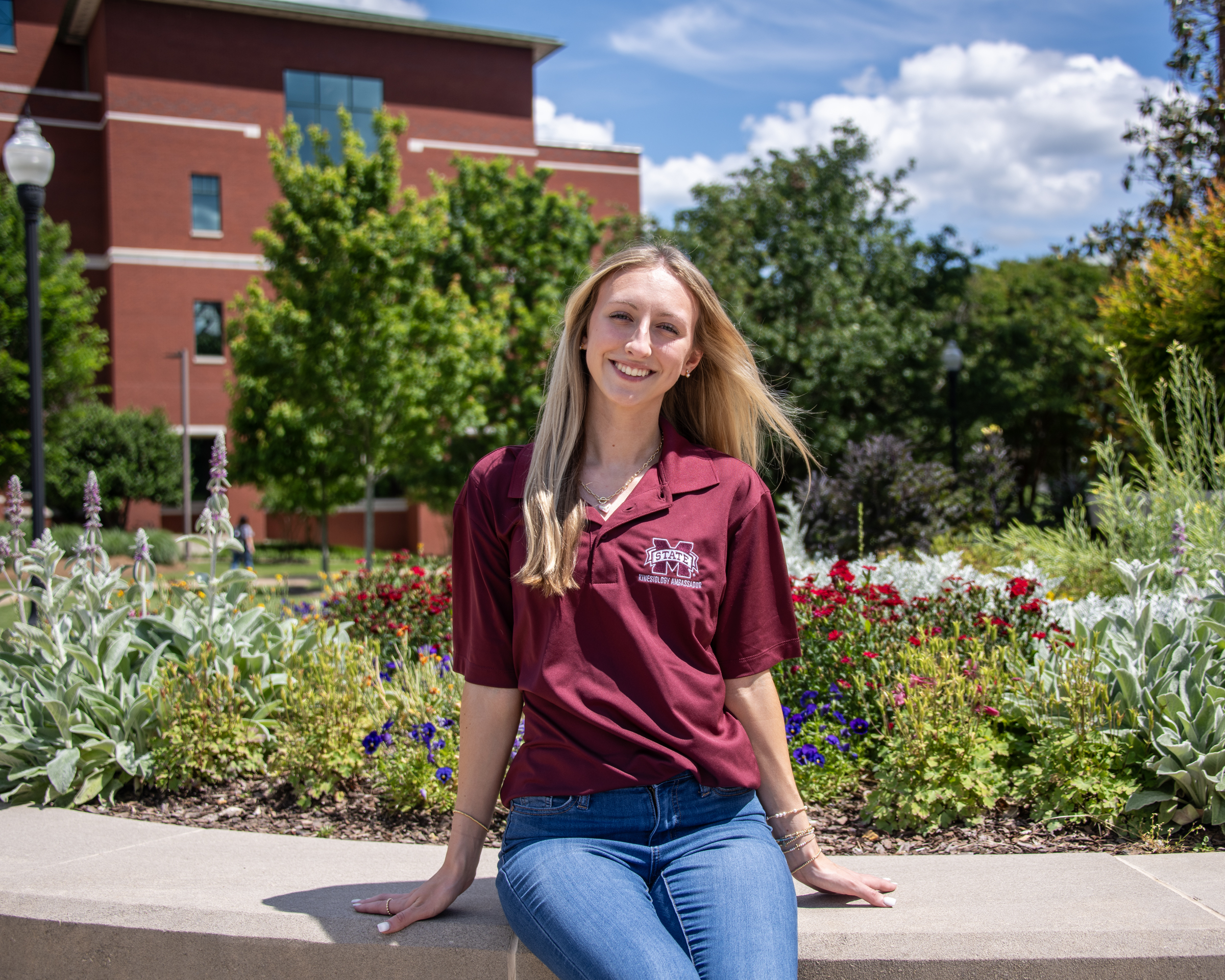 Student sitting in front of flowers